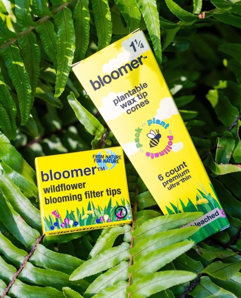 Bloomer filter tips and cones surrounded by vibrant wildflowers, promoting pollinator support and eco-friendly smoking solutions