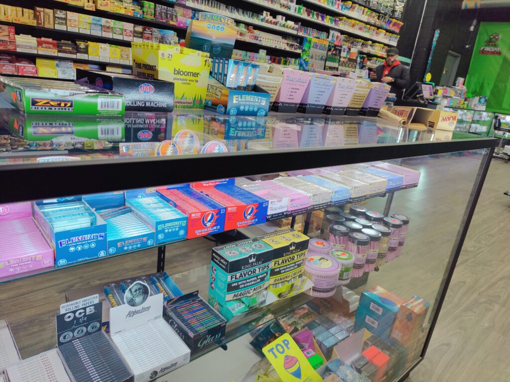 Bloomer display featuring a variety of rolling papers and cones. The image showcases different Bloomer products, including their eco-friendly filter tips and cones, arranged alongside various rolling papers. This display highlights the range of options available for environmentally conscious smokers.