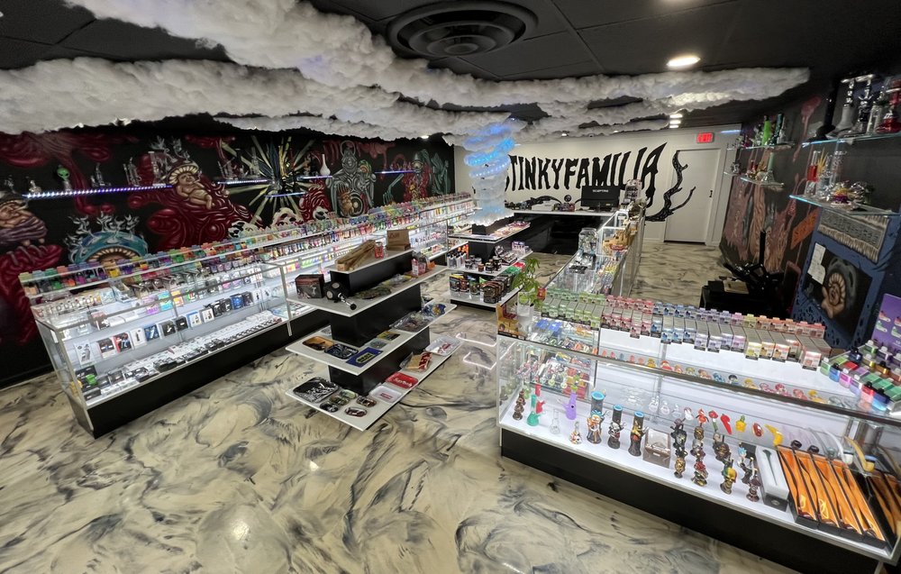 Aerial view of Stinky Familia smoke shop interior, showcasing diverse product displays, including Bloomer eco-friendly filter tips, in a well-organized, customer-friendly layout