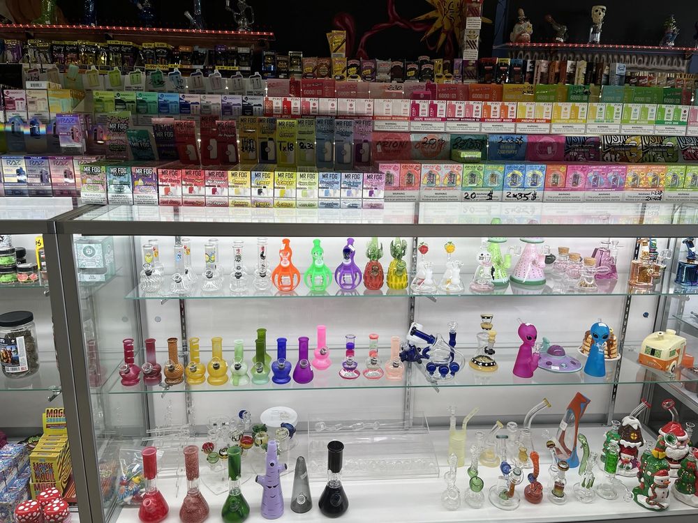 Stinky Familia smoke shop glass display featuring a variety of premium smoking accessories in Elk Grove Village, IL.