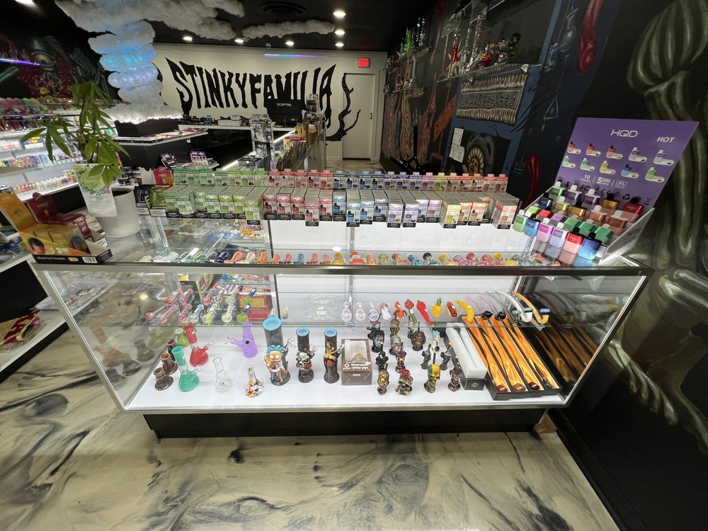 Stinky Familia smoke shop's extensive display of premium pipes, bongs, and vapes featuring Bloomer eco-friendly accessories in Elk Grove Village